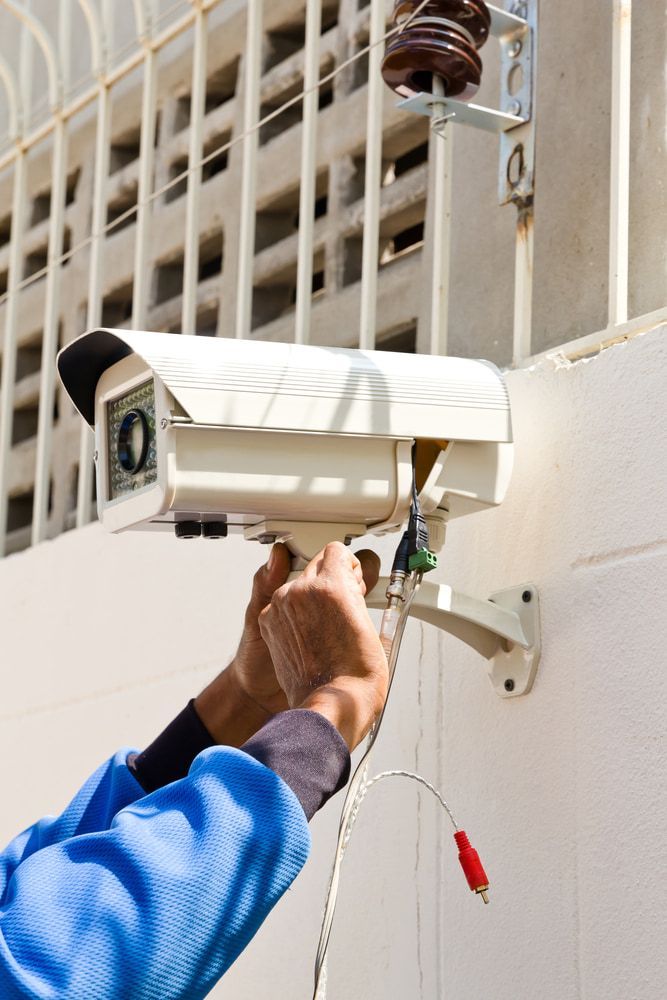A Person Is Installing a Security Camera — Active 247 Locksmith and Security Services Forster In Wingham, NSW