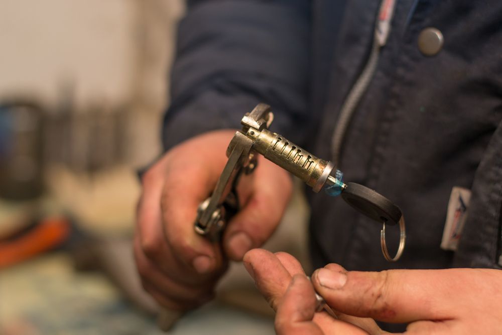 Person Holding a Car Key Cylinder and Key With Pliers — Active 247 Locksmith and Security Services Forster In Wingham, NSW
