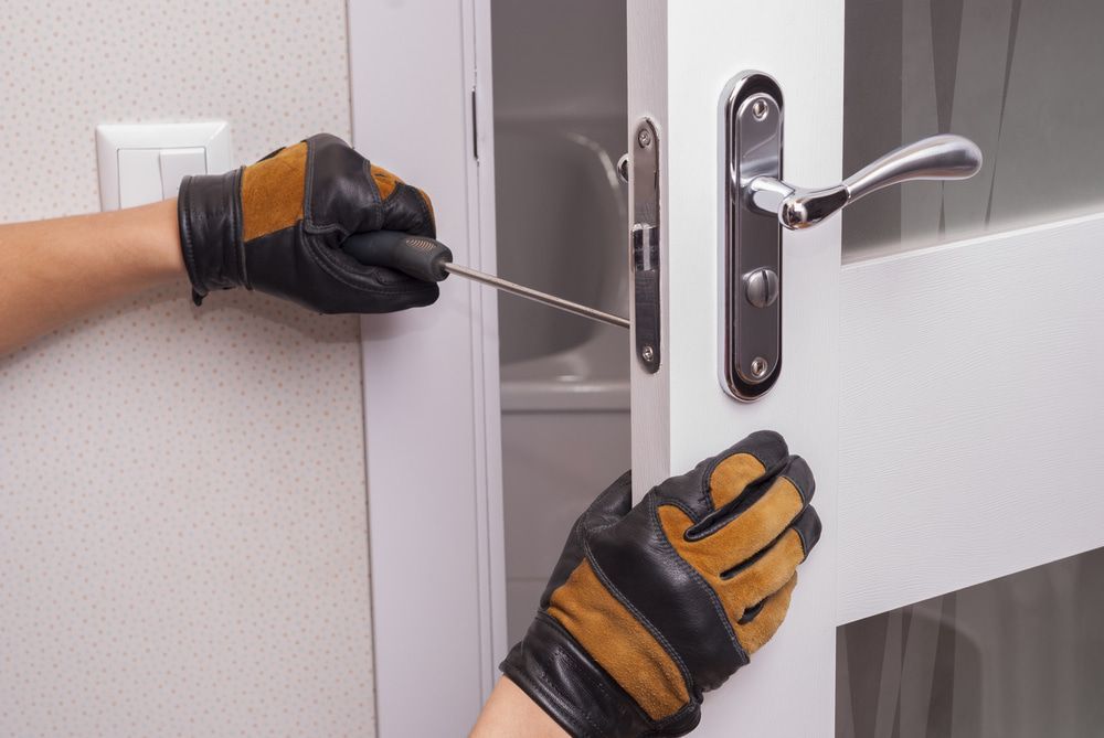 A Person Is Fixing a Door with A Screwdriver — Active 247 Locksmith and Security Services Forster In Forster, NSW