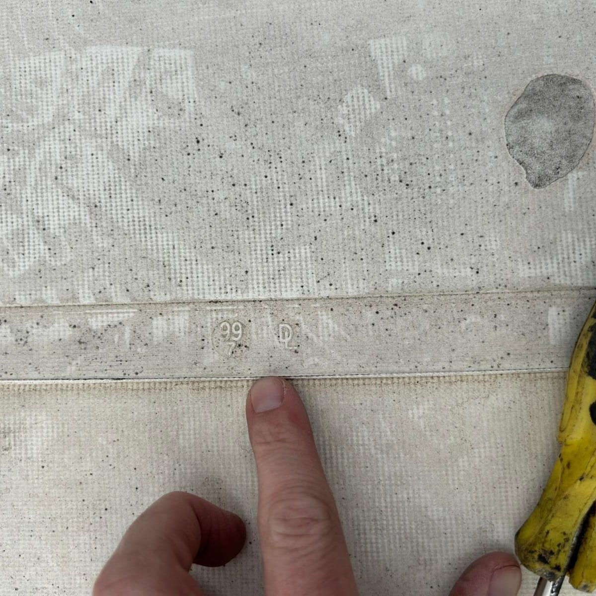 A person's finger points to the numbers 