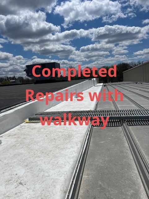 Completed repairs with walkway over white rooftop under cloudy sky