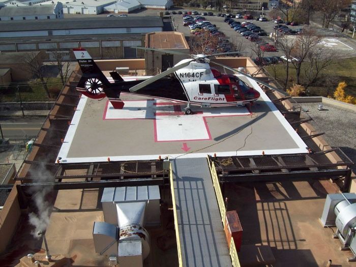 Helicopter on hospital rooftop helipad. Black, white, and red helicopter with