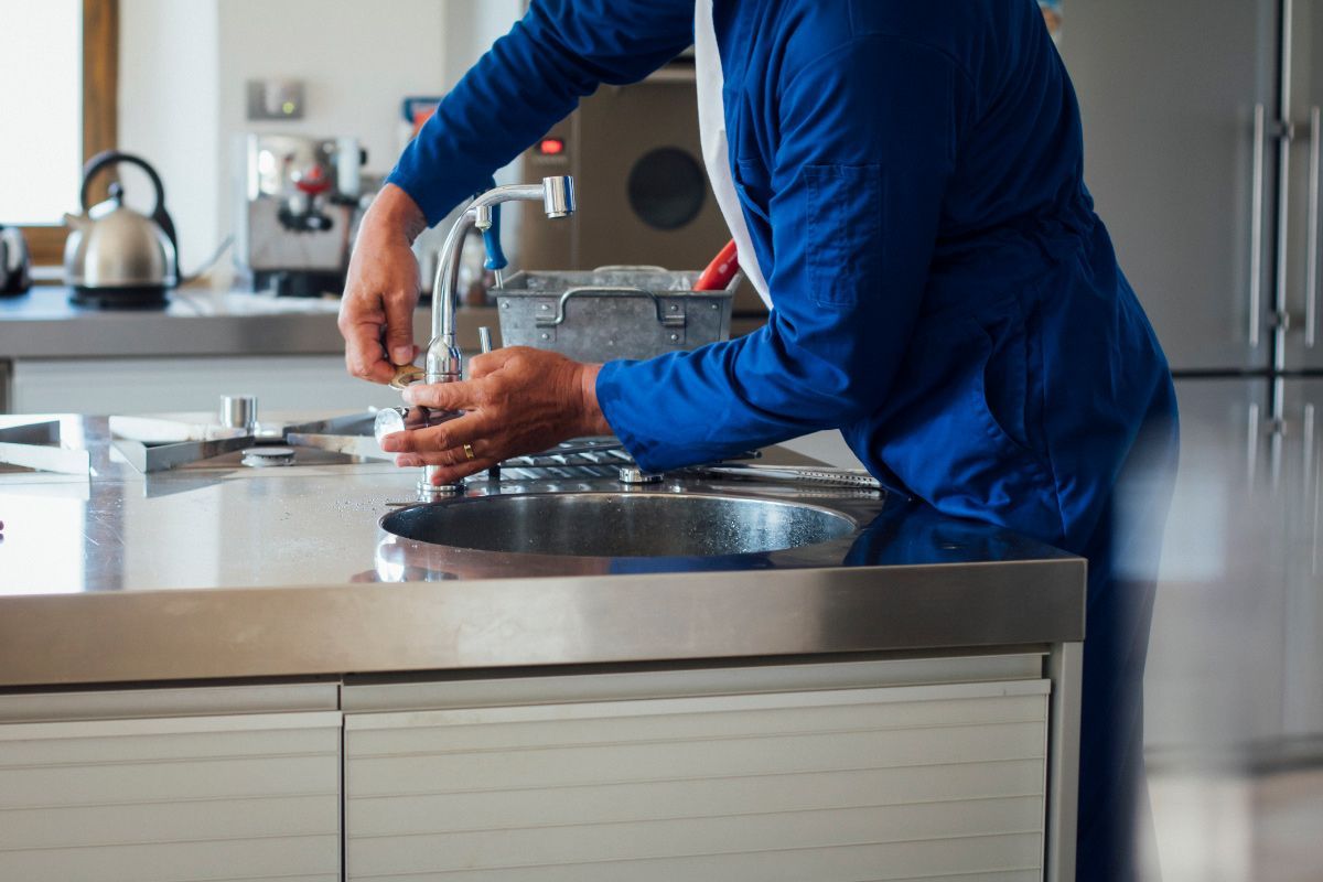 Working on Kitchen Sink — Cincinnati, OH — Mike Hensley Plumbing, Inc.