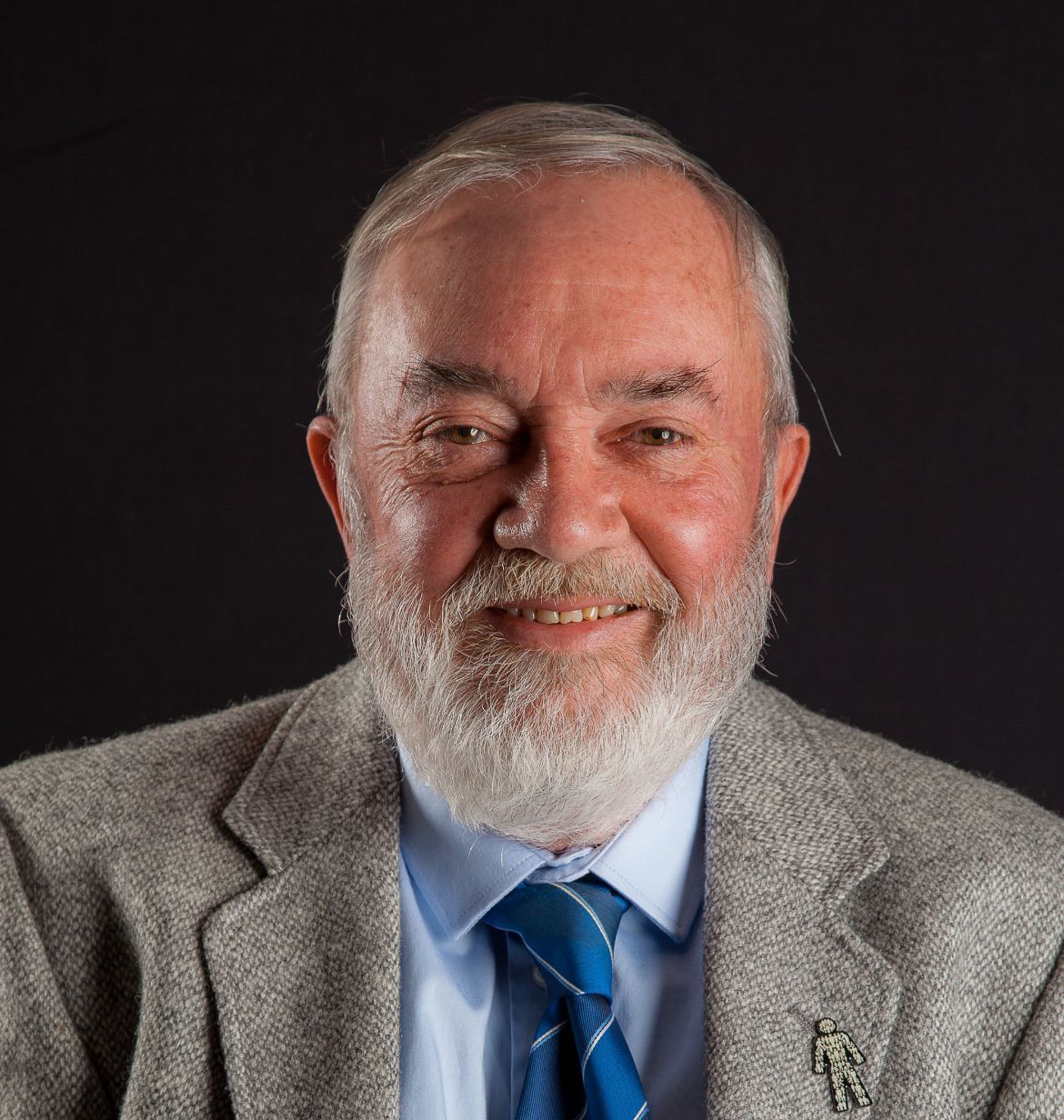 A man with a beard is wearing a suit and tie