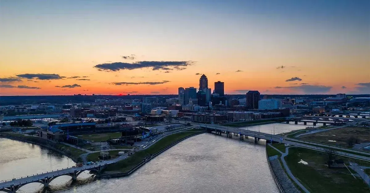 Aerial sunset view of a riverfront city skyline representing dumpster rental services