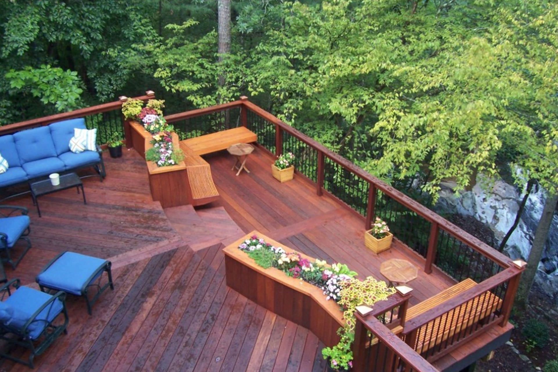Hot tub on a wooden deck next to a blue wall and a sliding glass door.