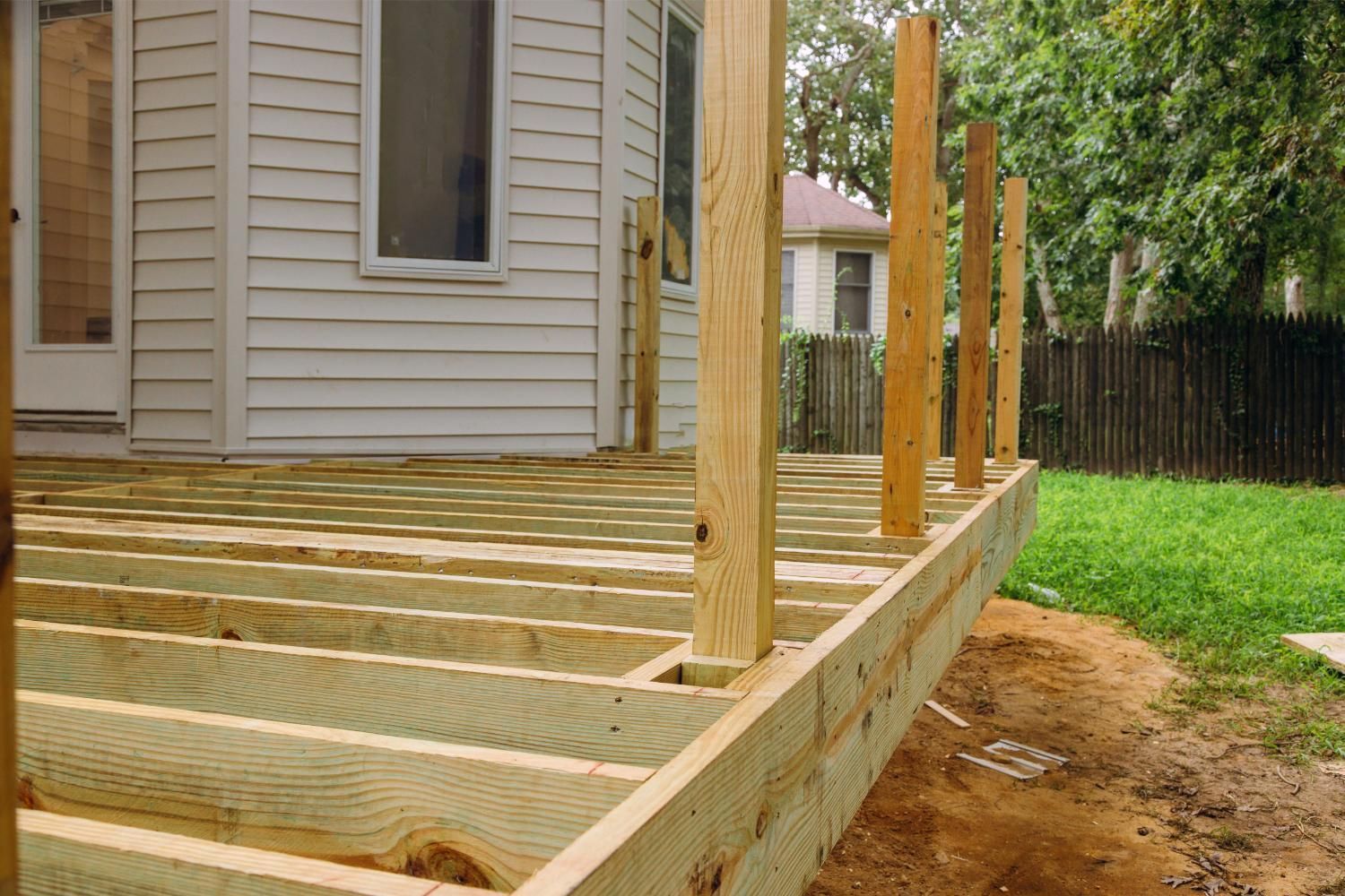 Wooden fenced enclosure, likely for a garden or animals, in an outdoor setting under a clear sky.