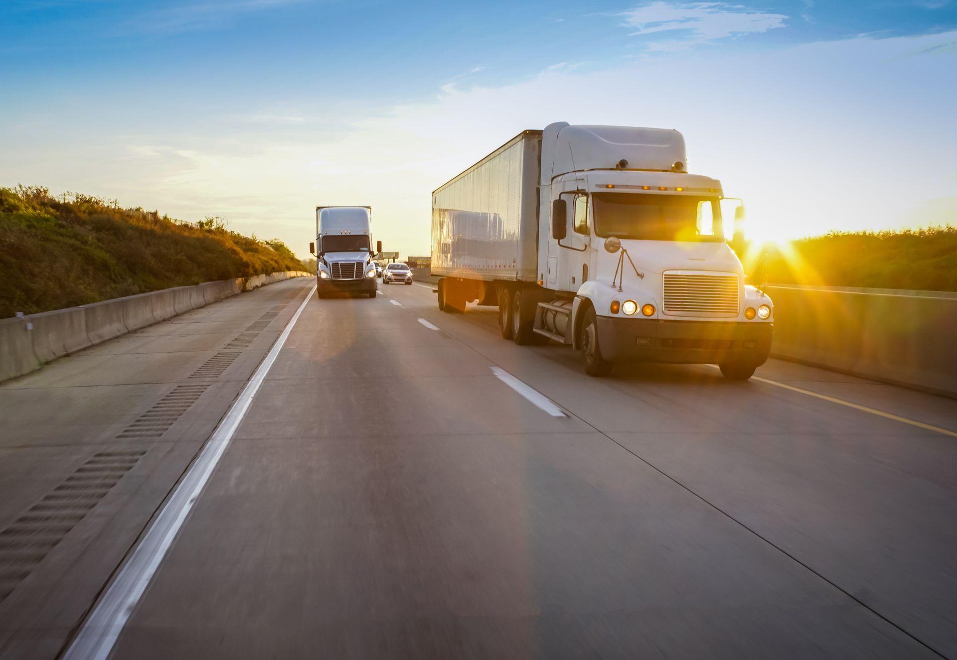 Two semi trucks are driving down a highway at sunset. Two semi trucks are driving down a highway at sunset.
