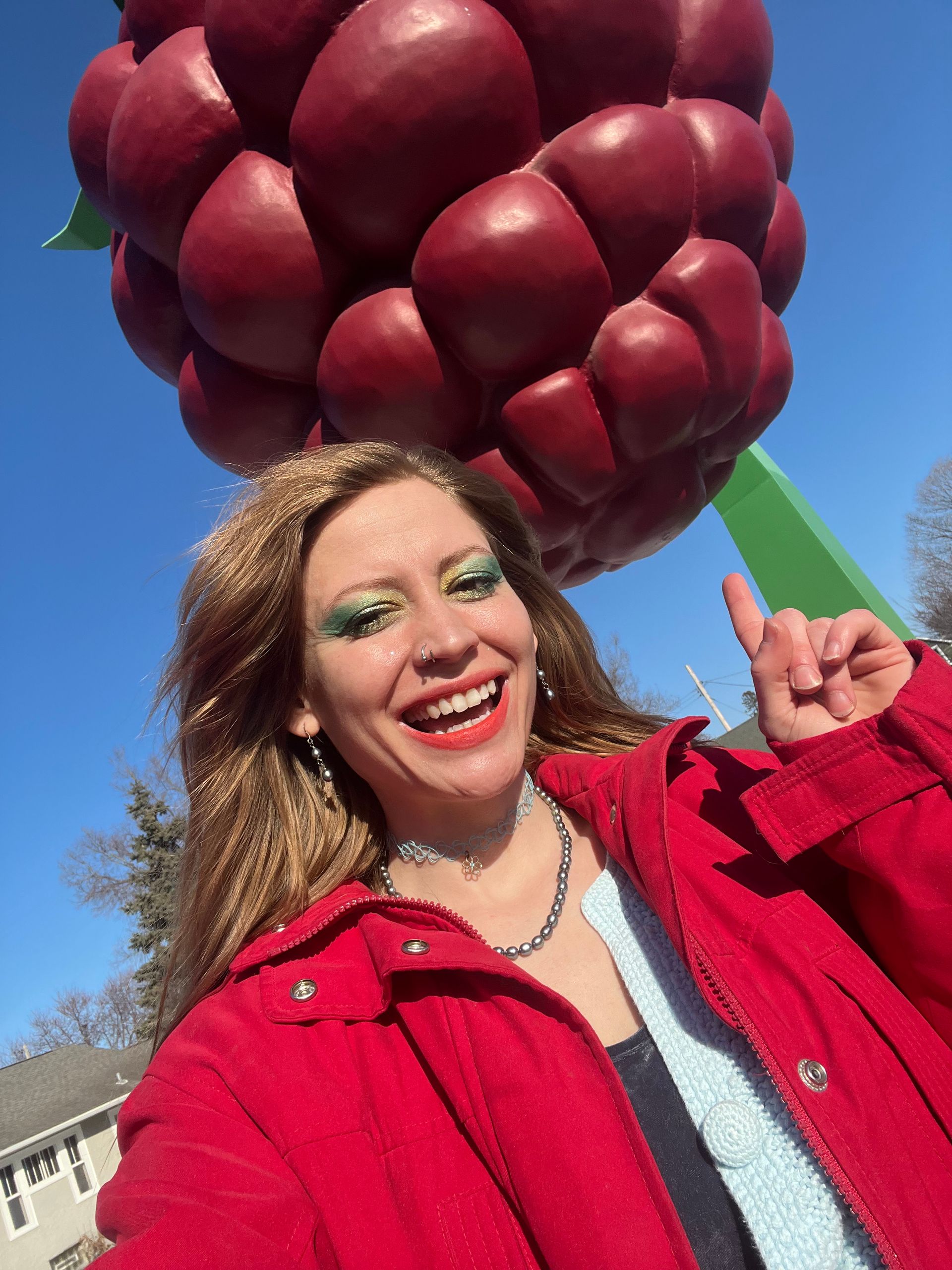 woman in front of a big grape sculpture