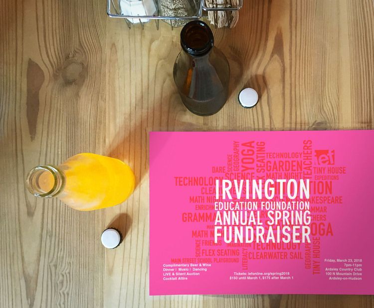 A bottle of orange juice sits on a table next to an invitation for an annual spring fundraiser