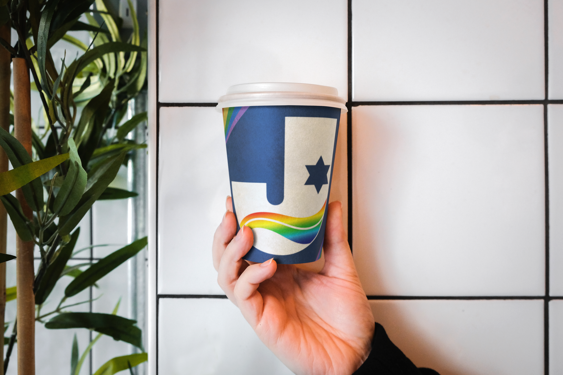A person is holding a cup of coffee in their hand.