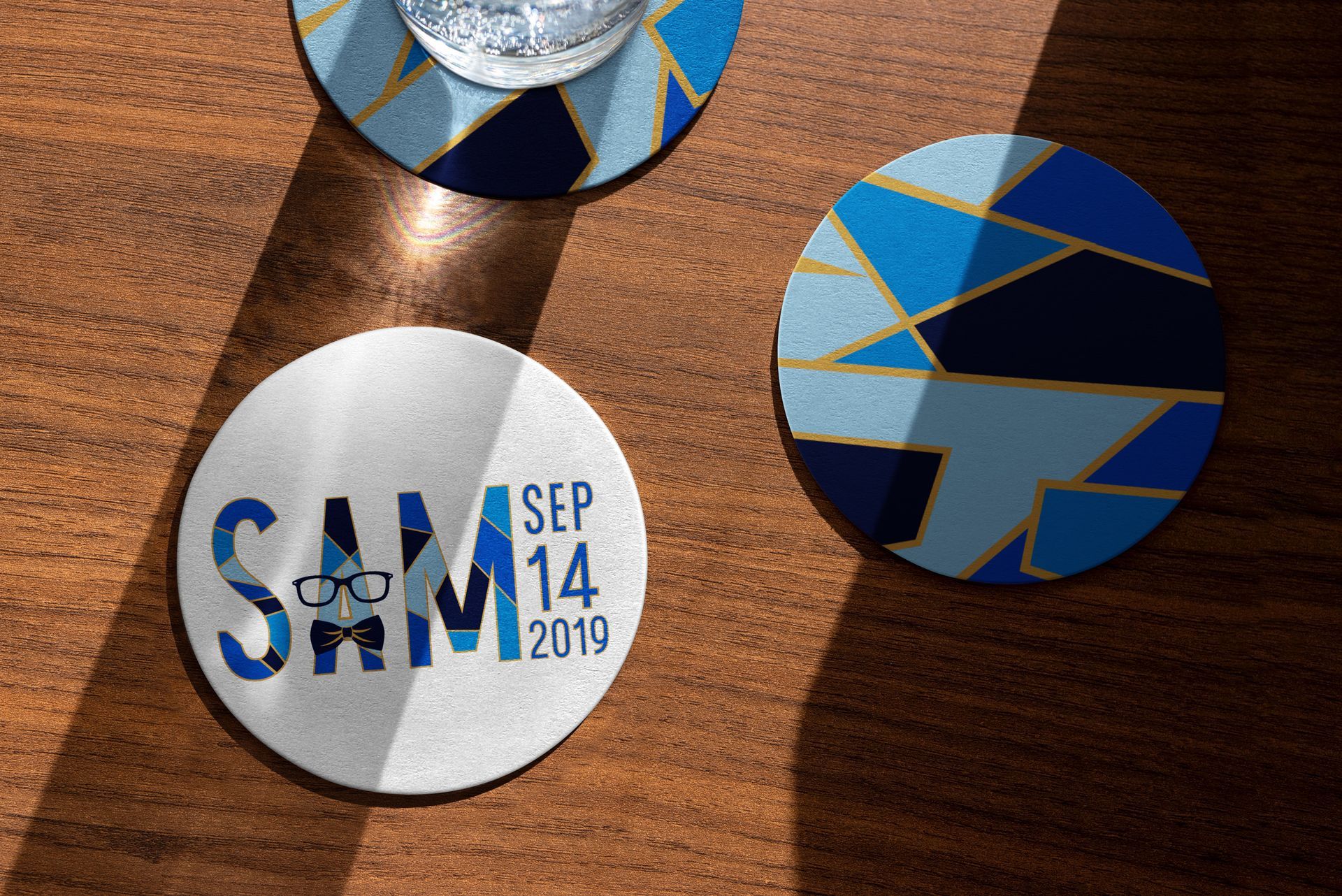 Three coasters with the name sam on them are sitting on a wooden table.