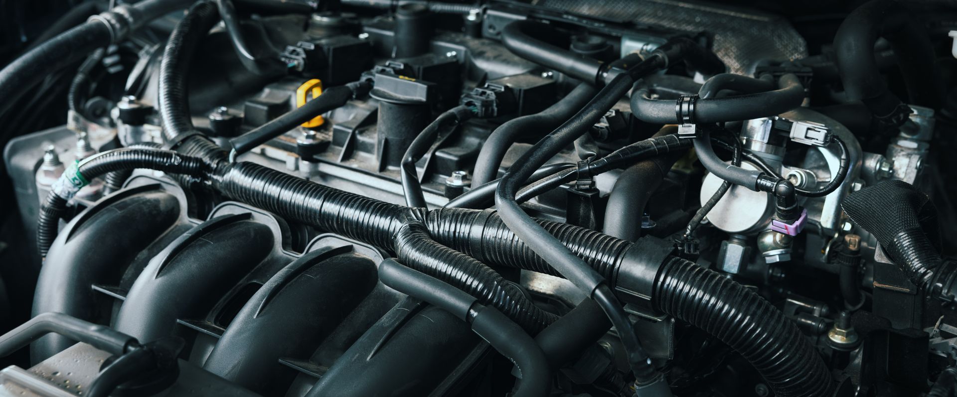 Car engine with various black tubes and components.