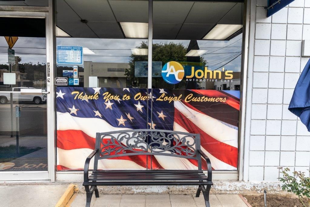 A business entrance with a bench, American flag banner, and 