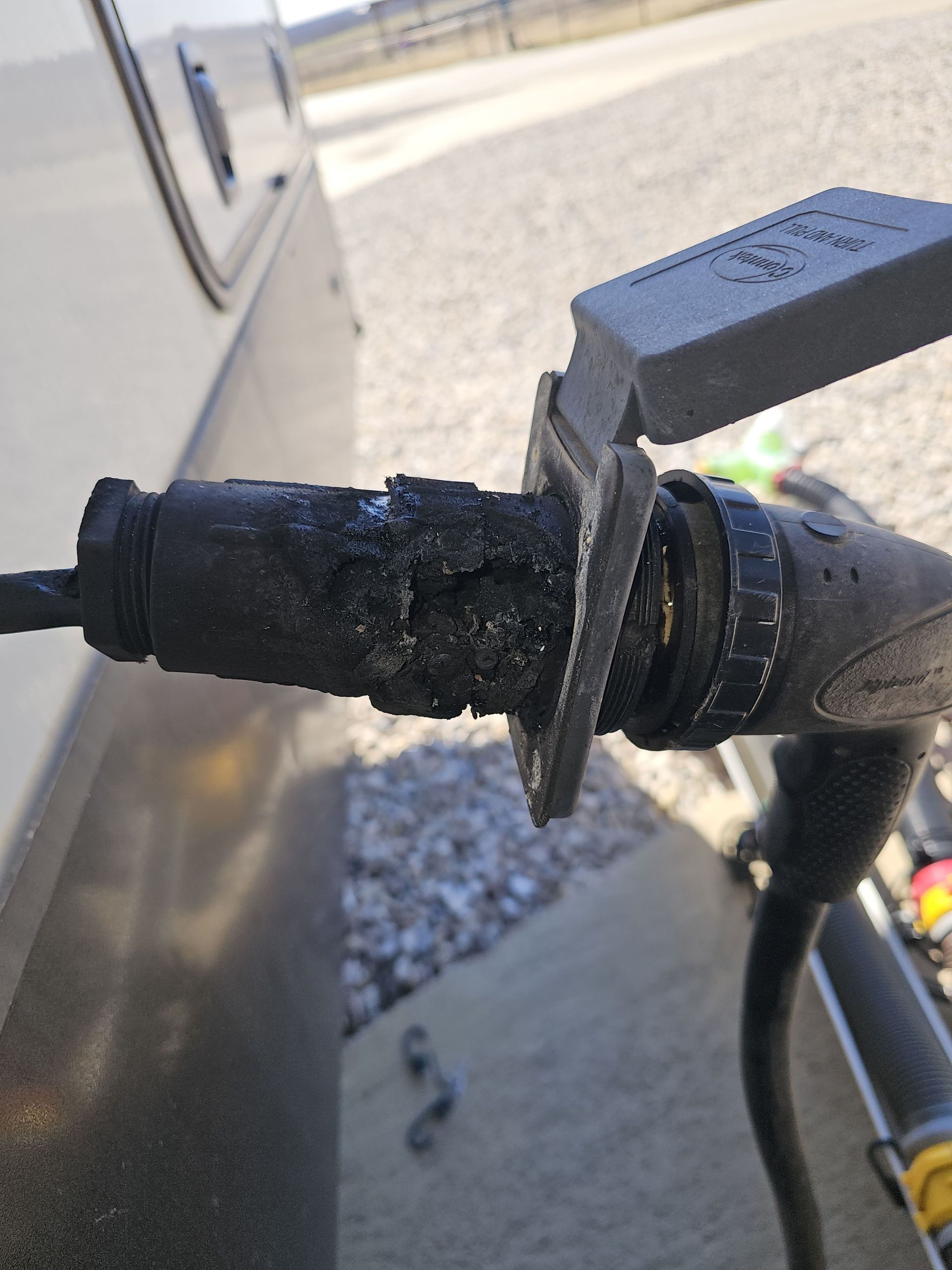 Close-up of a bike handlebar grip and brake lever beside a wall in bright sunlight