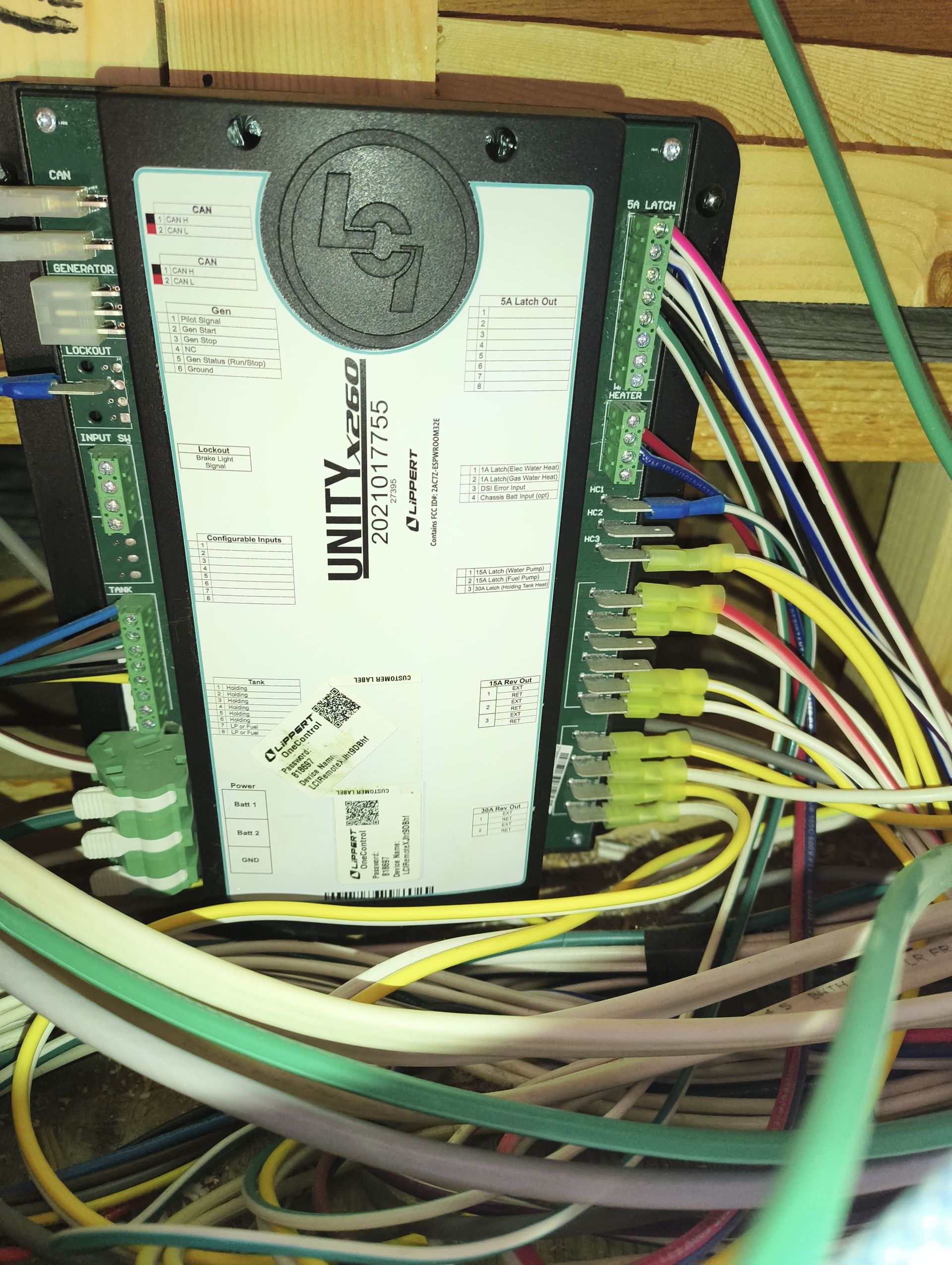 Wired industrial control module with multicolored cables connected on a wooden surface