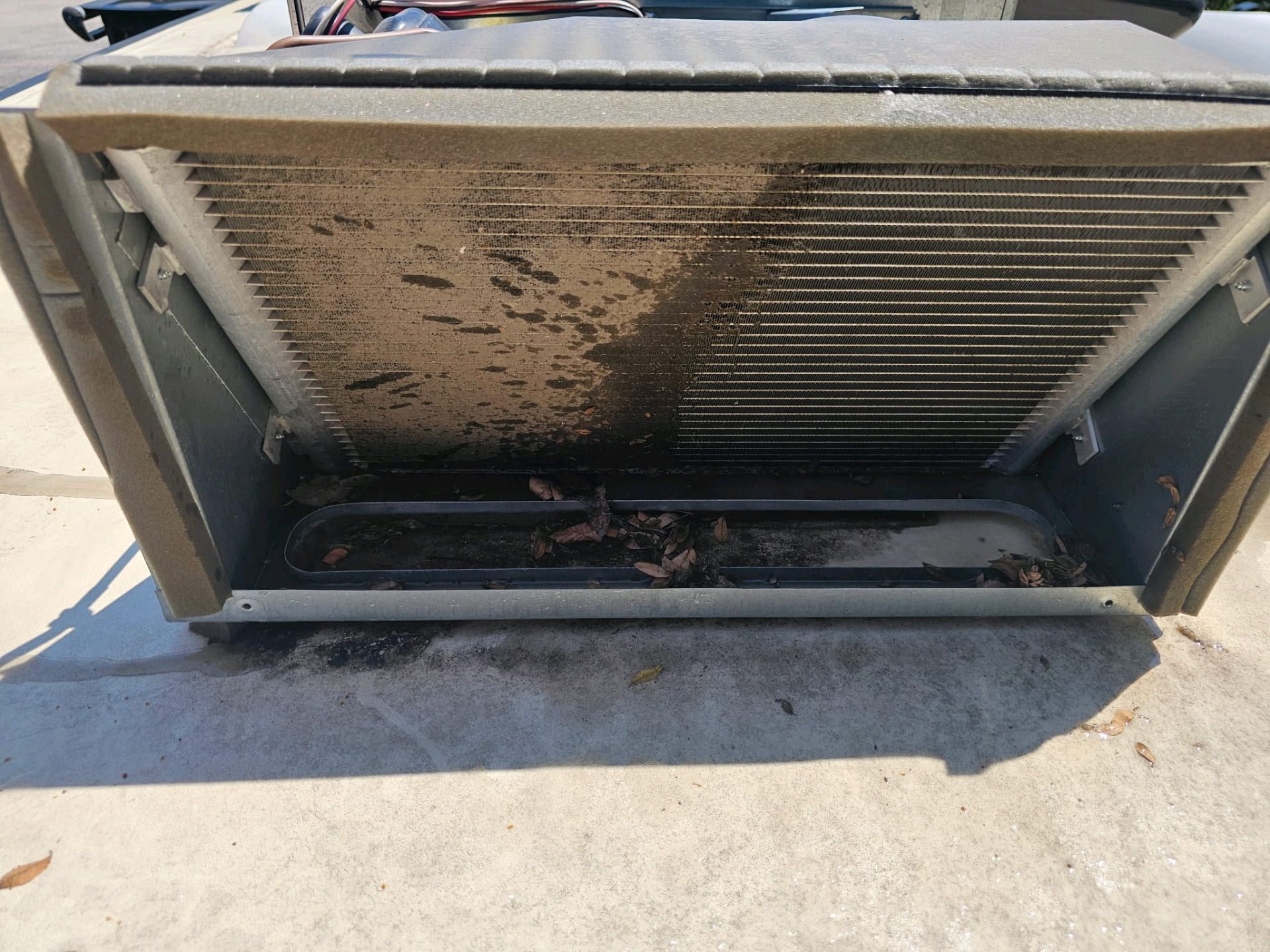 Dirty outdoor HVAC unit with debris clogging the vent and condenser coils.