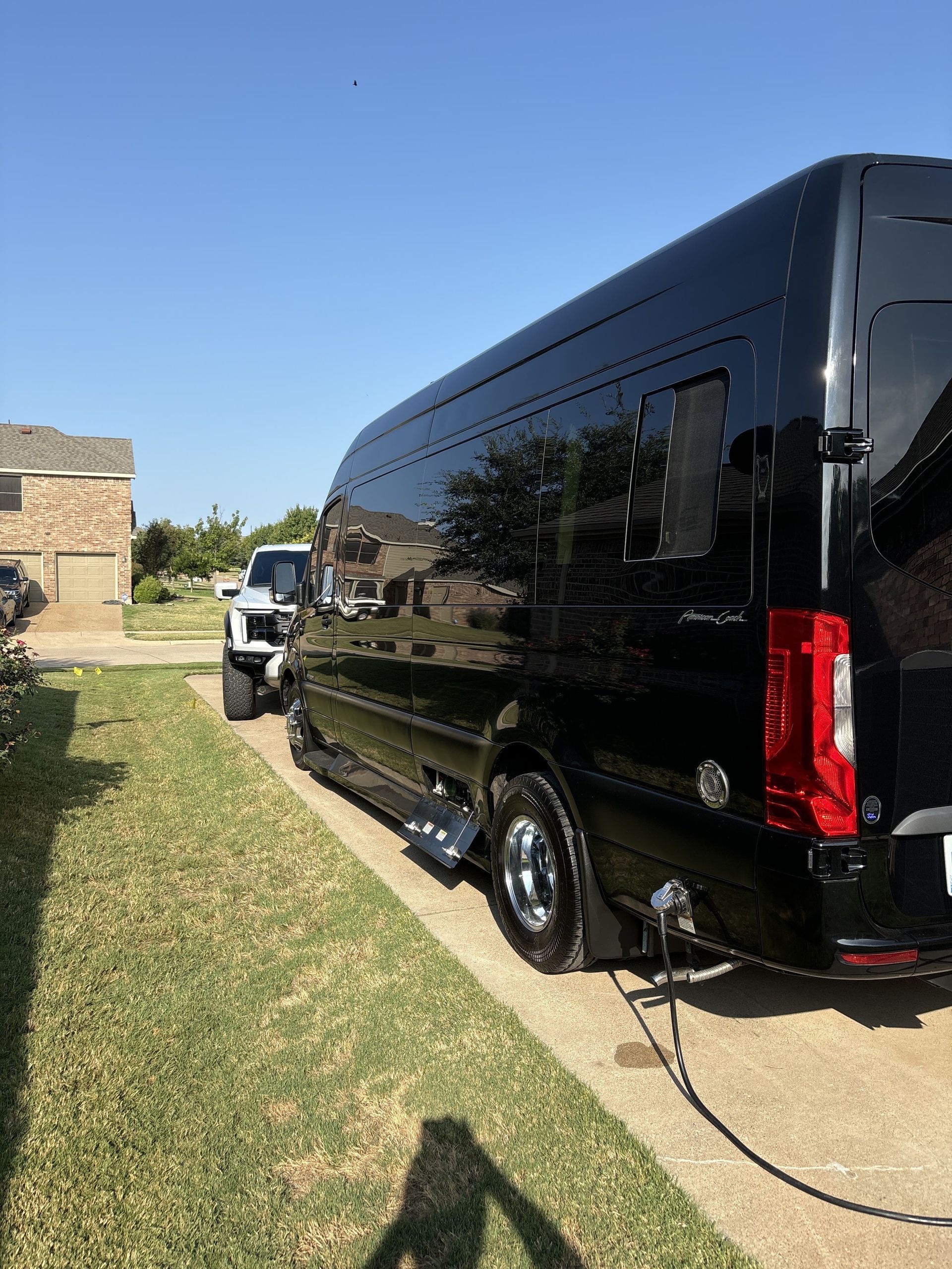 Black box trailer parked on a driveway beside a house, with a tow vehicle attached.