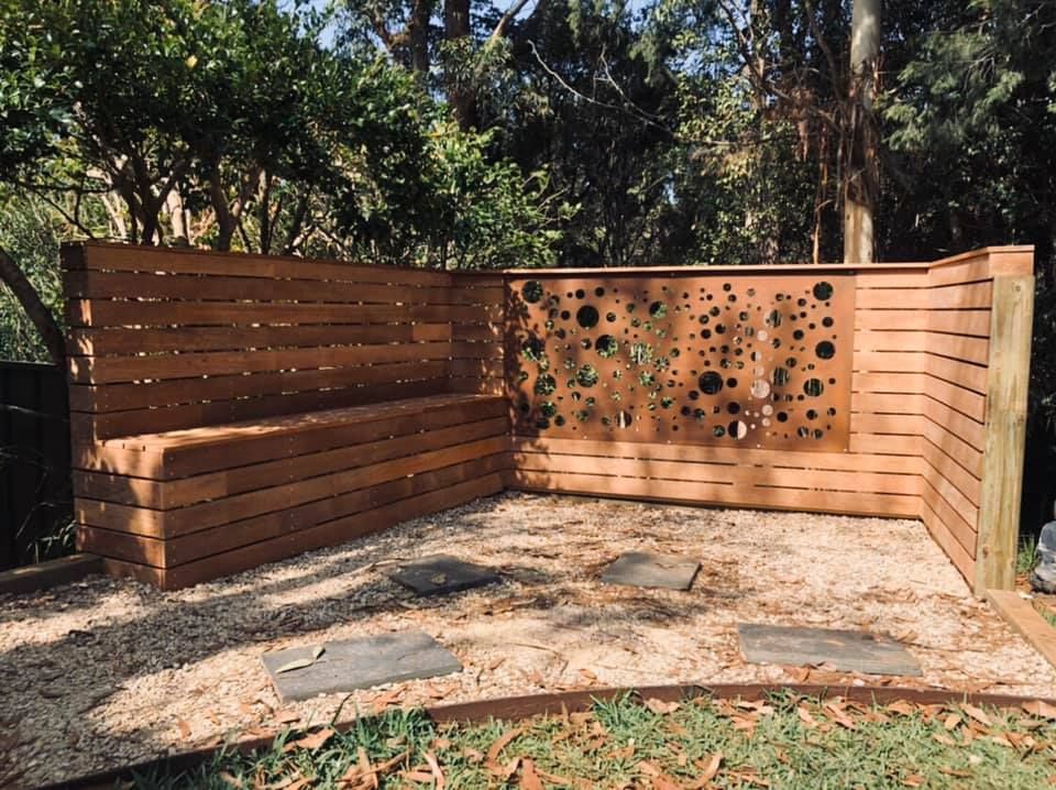 A Wooden Bench Is Sitting In The Middle Of A Wooden Fence — J.White Carpentry & Renovations in Port Macquarie, NSW 