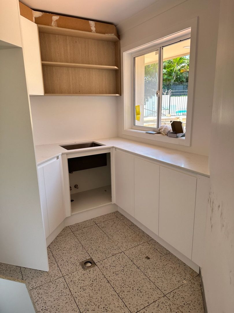 A kitchen with white cabinets , a sink , and a window. — J.White Carpentry & Renovations in Port Macquarie, NSW 