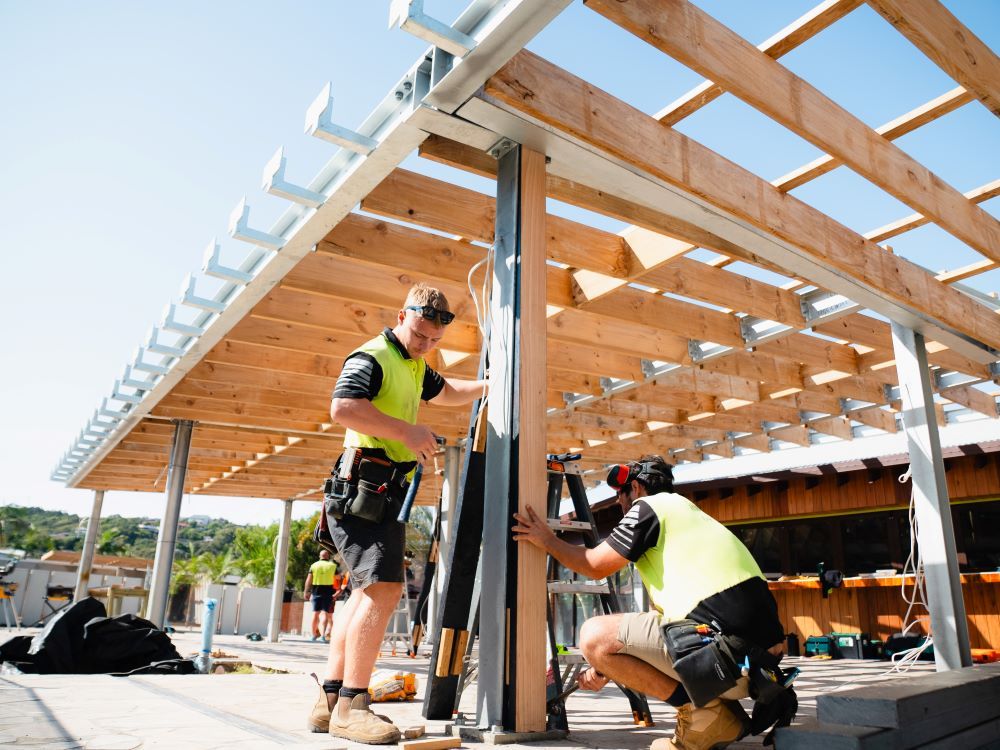 Two Construction Workers Are Working On A Wooden Structure — J.White Carpentry & Renovations in Port Macquarie, NSW 