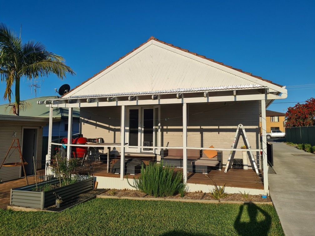 A house with a screened in porch and a ladder in front of it — J.White Carpentry & Renovations in Port Macquarie, NSW 