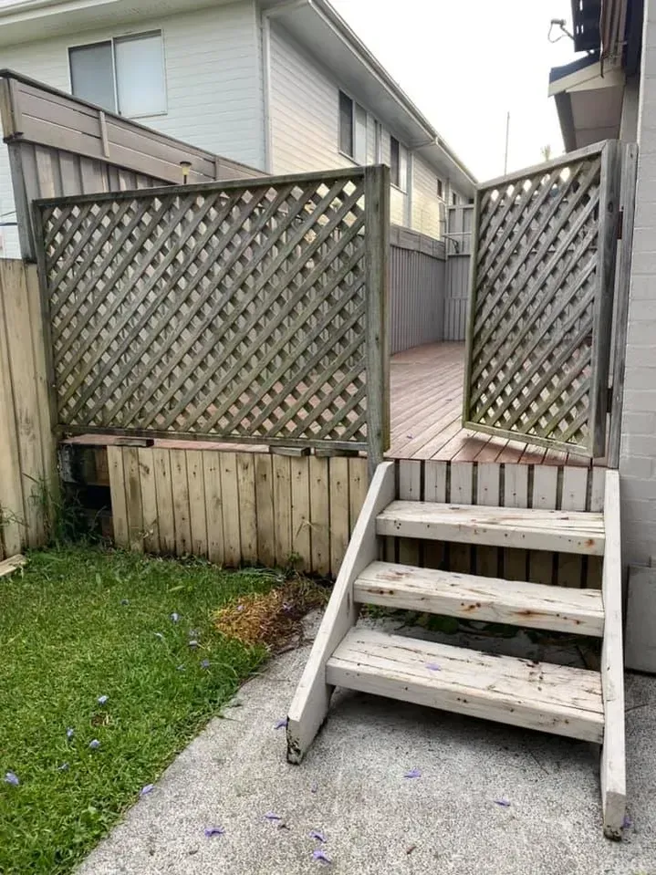 A wooden deck with stairs leading up to it and a wooden fence. — J.White Carpentry & Renovations in Port Macquarie, NSW 