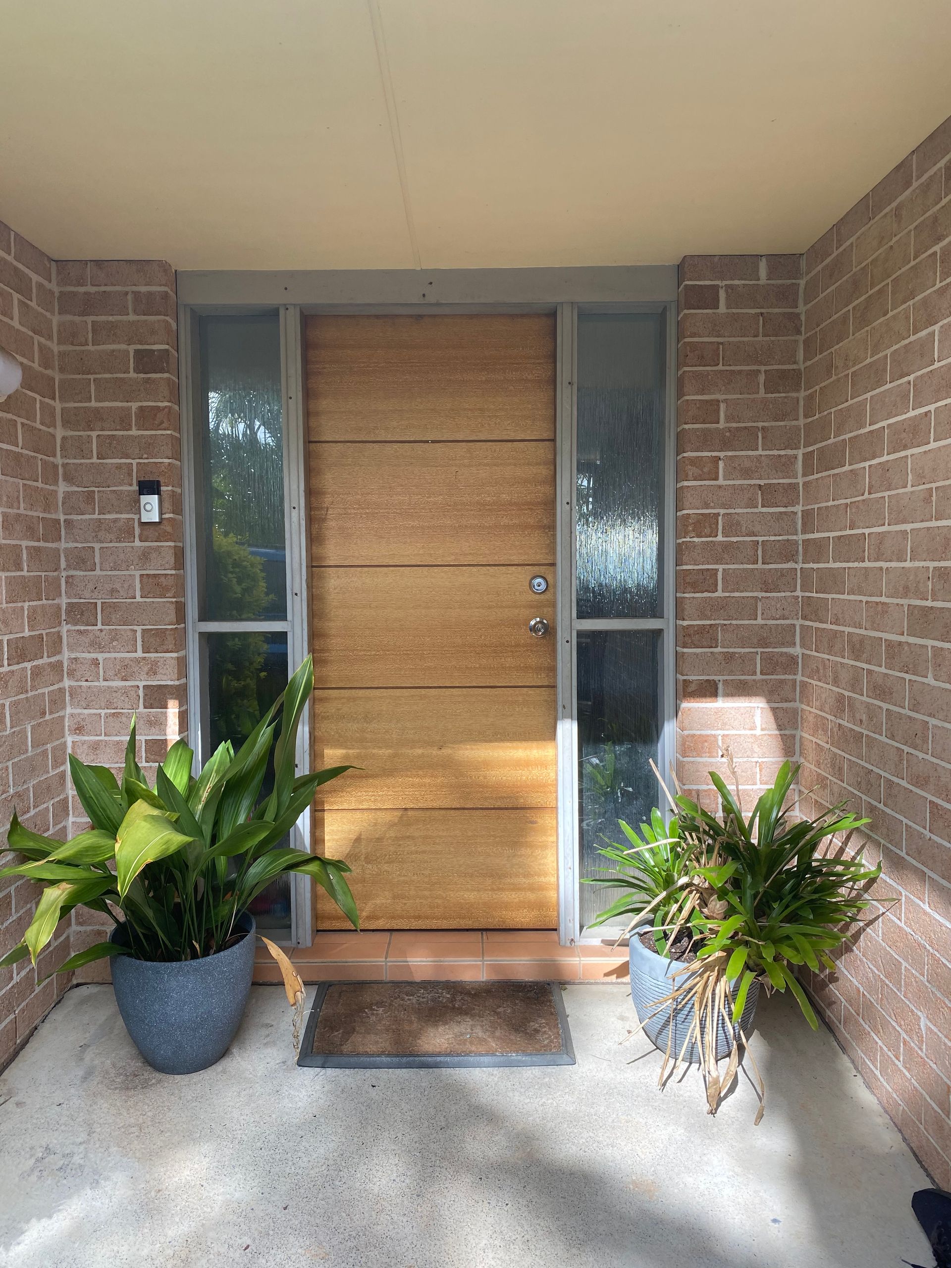 Front door of a  house with a wooden door and plants in front of it. — J.White Carpentry & Renovations in Port Macquarie, NSW