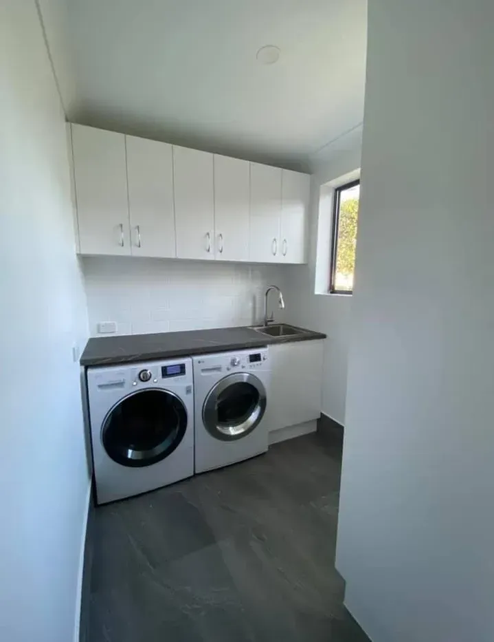 A laundry room with a washer and dryer and a sink. — J.White Carpentry & Renovations in Port Macquarie, NSW