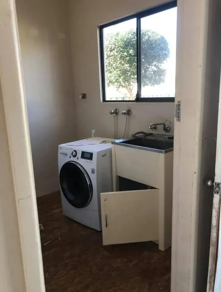 A laundry room with a washer and dryer and a sink. — J.White Carpentry & Renovations in Port Macquarie, NSW 