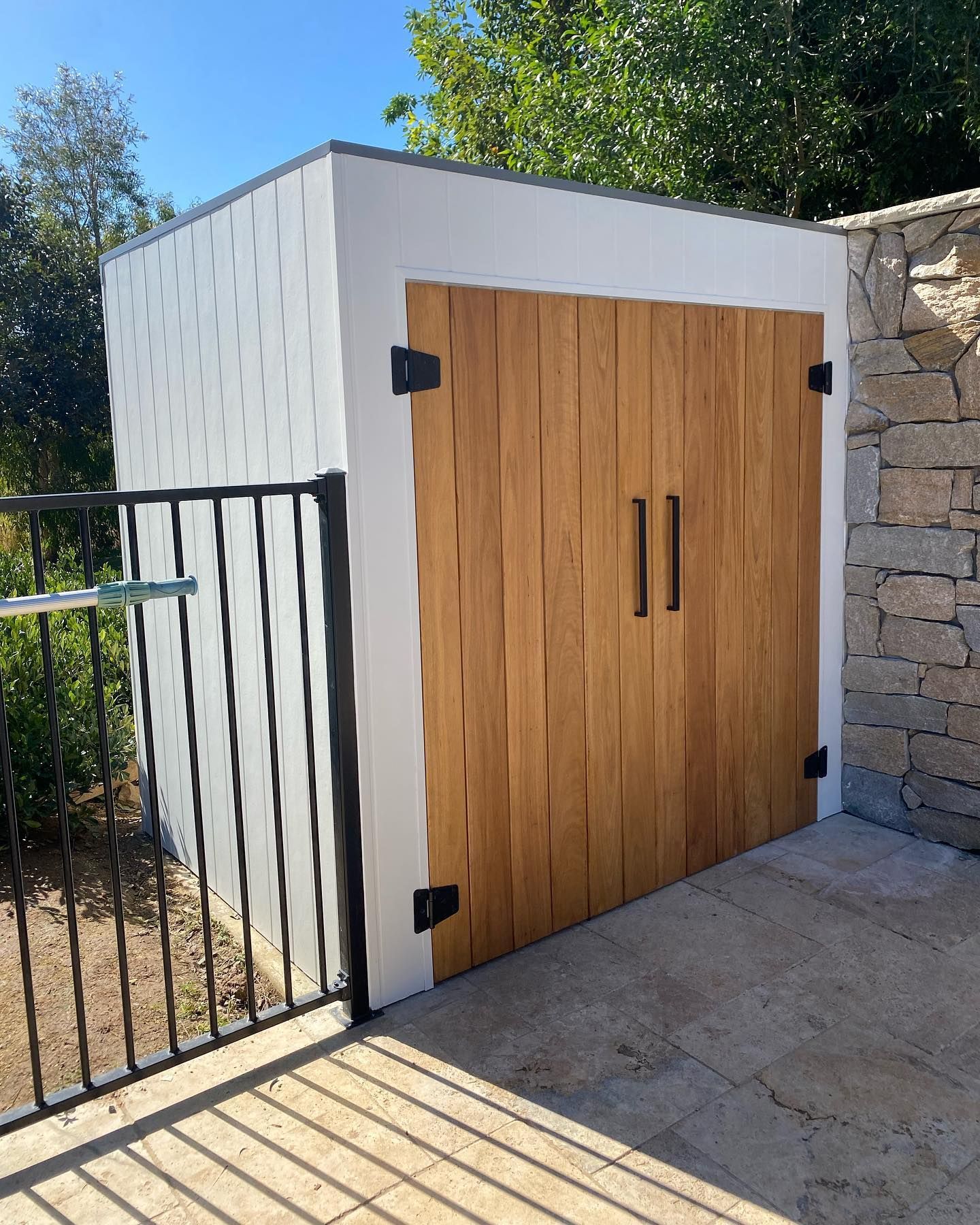 A white building with wooden doors and a wrought iron fence. — J.White Carpentry & Renovations in Port Macquarie, NSW