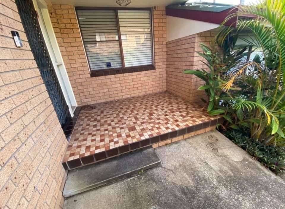 A brick house with a tiled porch and a window. — J.White Carpentry & Renovations in Port Macquarie, NSW 