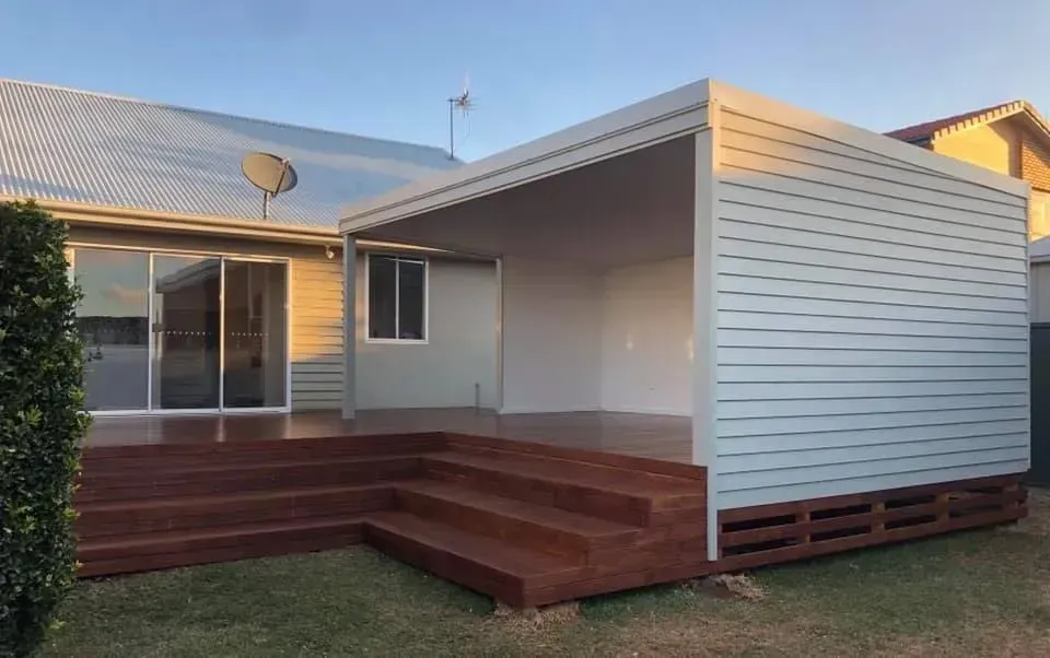 A house with a wooden deck and stairs in front of it. — J.White Carpentry & Renovations in Port Macquarie, NSW