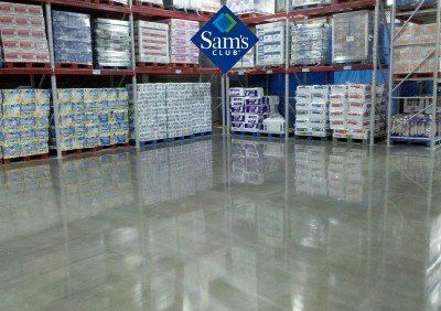 Sam's Club warehouse aisle with stacked pallets and polished floor reflecting the shelves