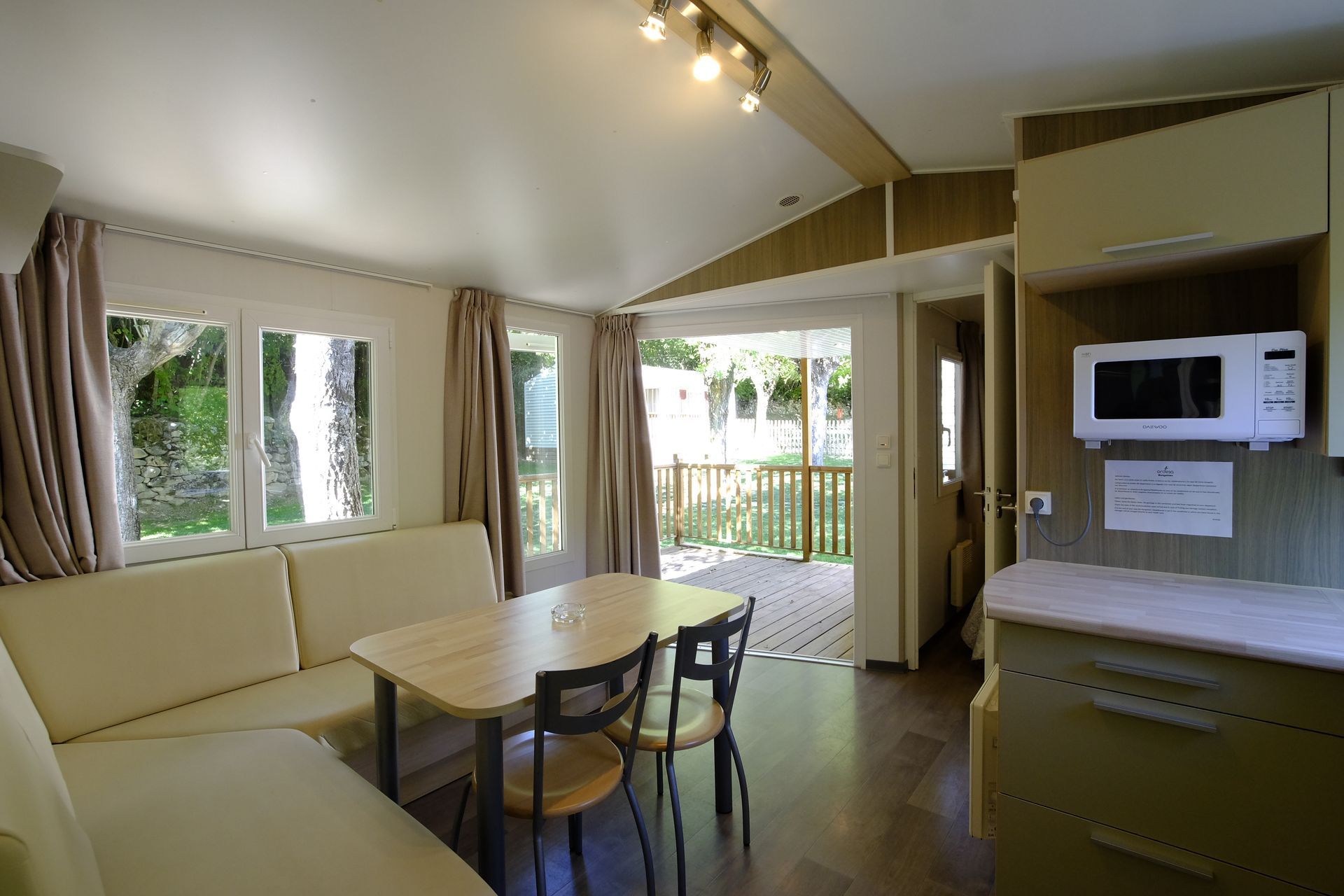 Interior de la casa móvil, donde se muestran la cocina, la mesa de comedor, el sofá y el acceso a la terraza.