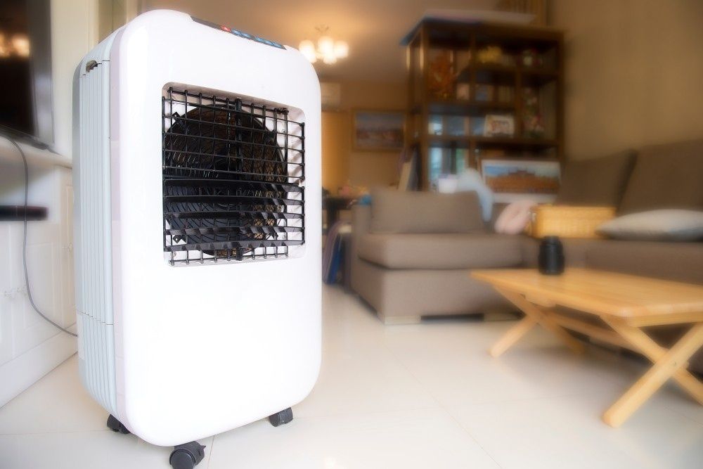 White Portable Air Cooler with A Black Grill in A Living Room — Messina Air Conditioning & Electrical in Edmonton, QLD