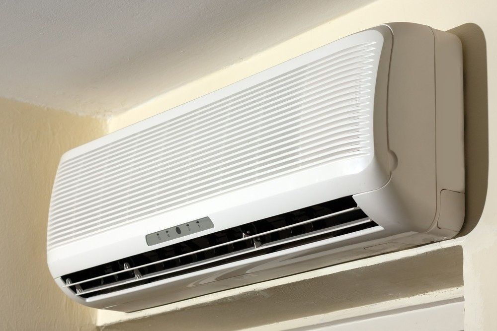White Wall-Mounted Air Conditioner Against a Light-Colored Wall — Messina Air Conditioning & Electrical in Portsmith, QLD