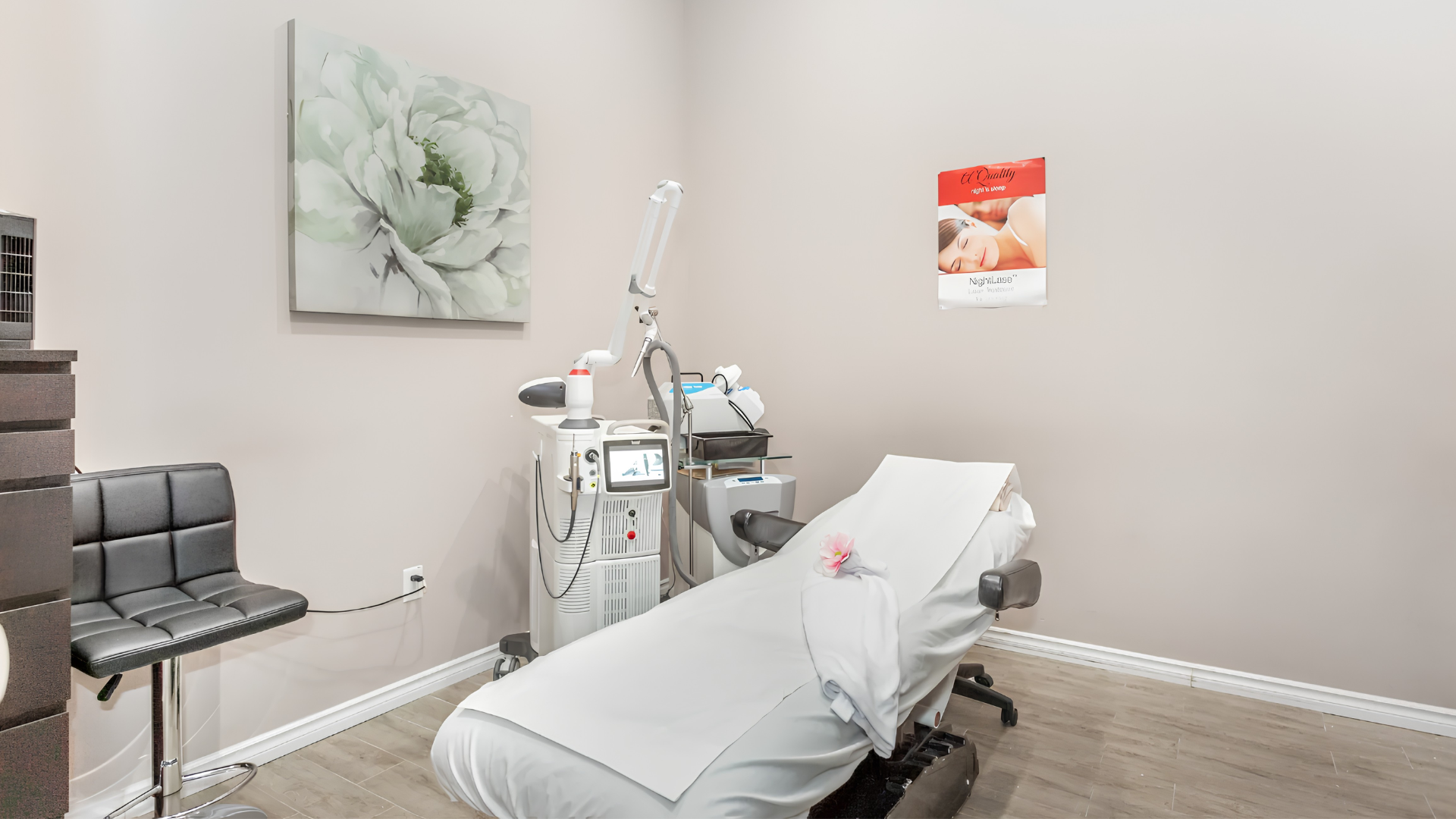 Medical exam room with treatment chair, diagnostic equipment, and wall art