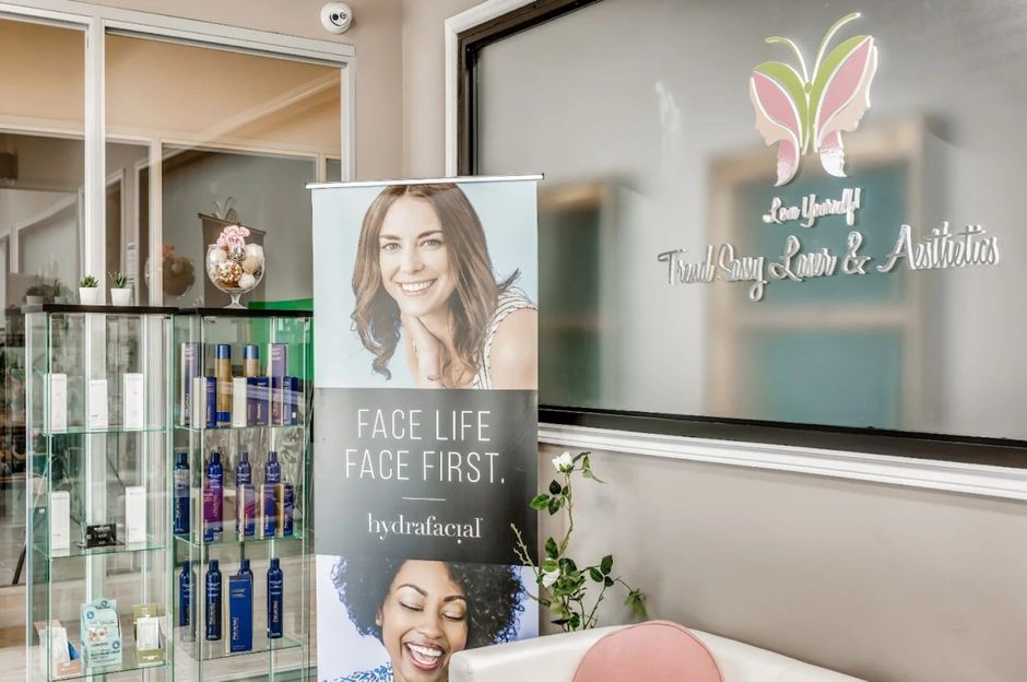 Spa reception with product display, wellness banner, and frosted glass logo signage