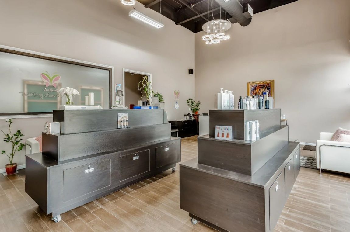 Modern dental office reception area with gray counters, white walls, and wood flooring