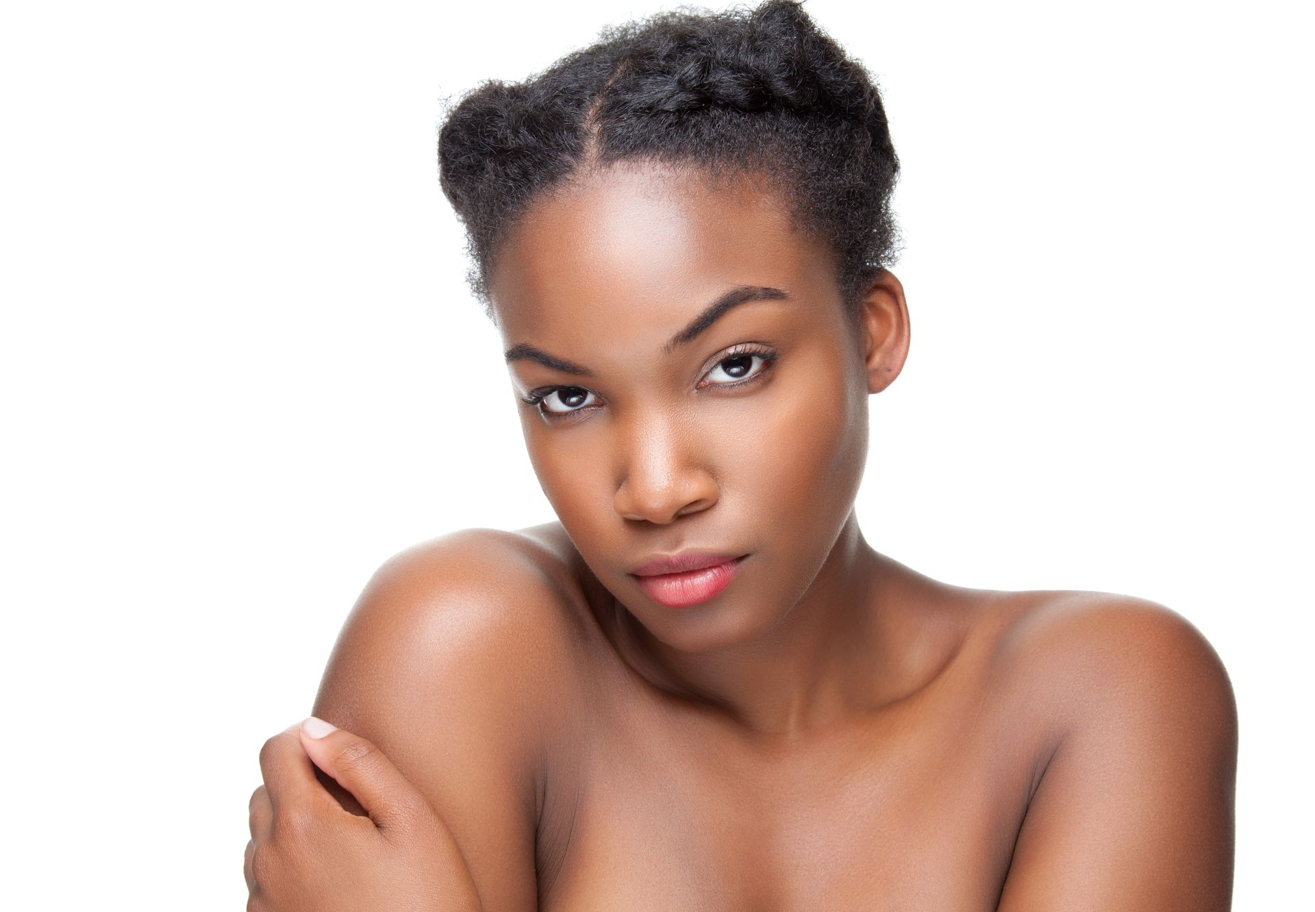 Portrait of a person with short natural hair, bare shoulders, and a neutral expression against a white background
