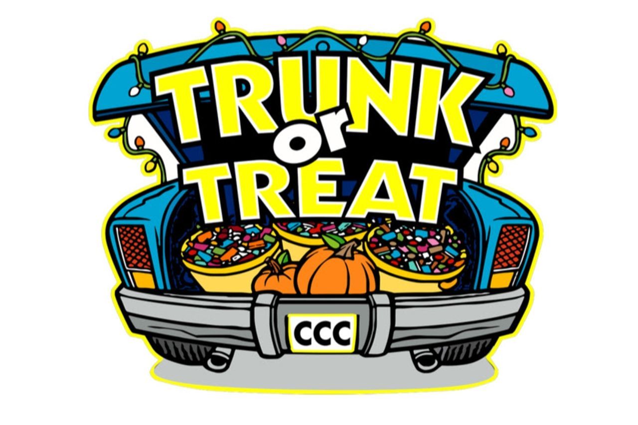 The trunk of a car is filled with buckets of candy and pumpkins.