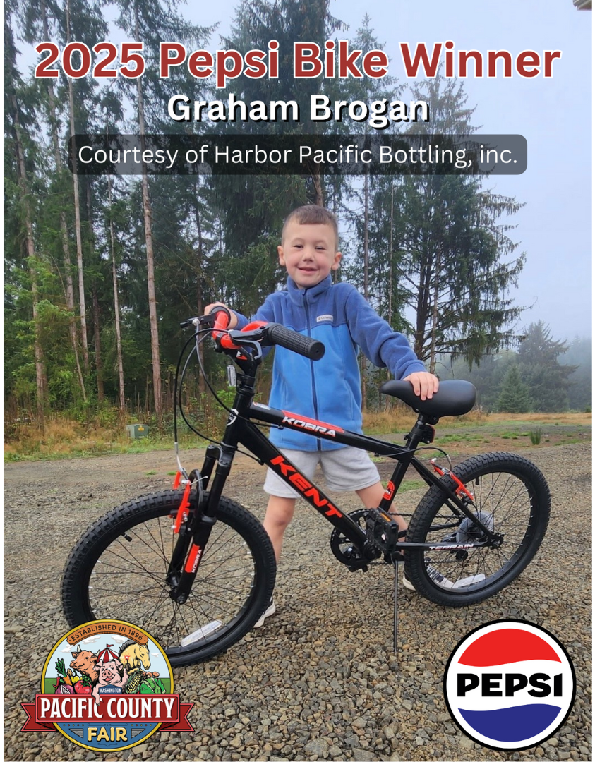 A young boy stands outdoors with a new black and red Kent bicycle, celebrating his 2025 Pepsi Bike contest win.