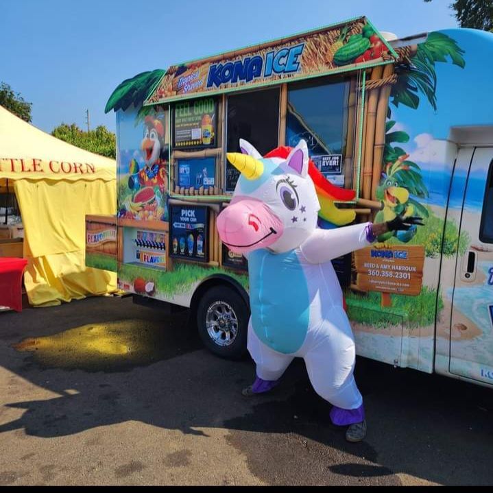 A unicorn mascot is standing in front of a food truck that says kong ice