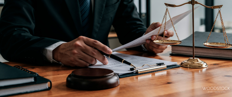 Solicitor reviewing legal documents at a desk with scales of justice and gavel, representing legal advice and case preparation.