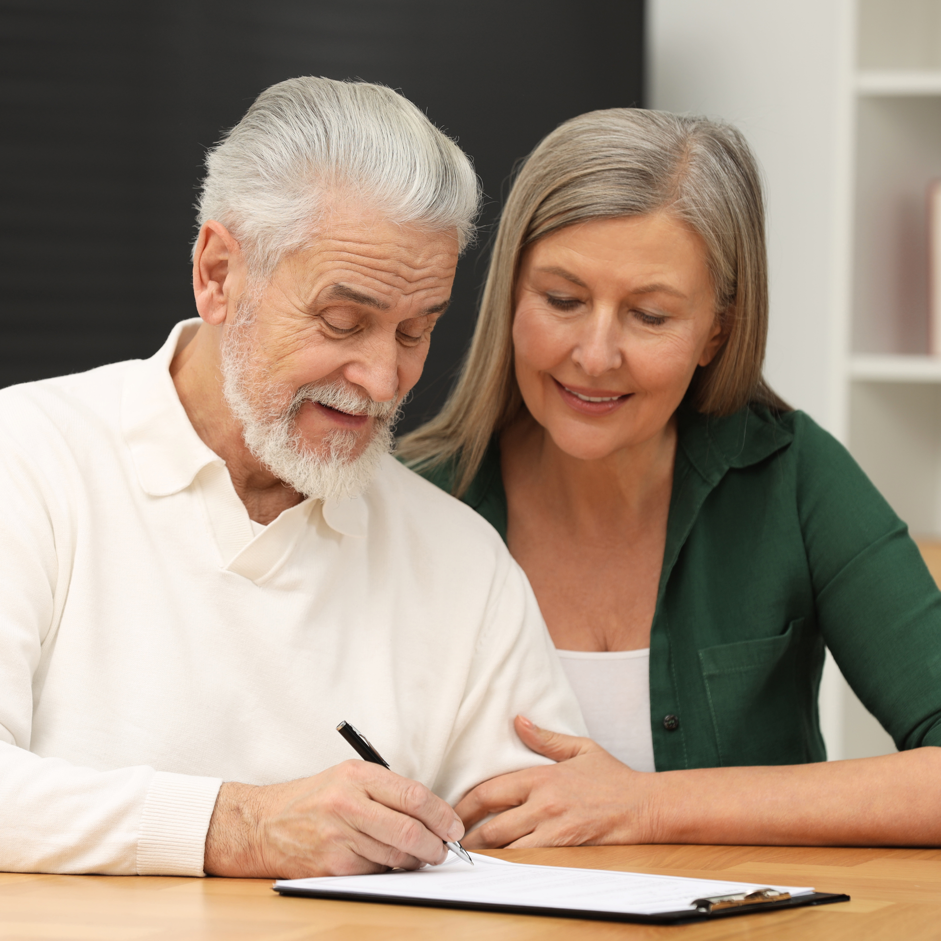 Older couple reviewing a tablet with an adviser