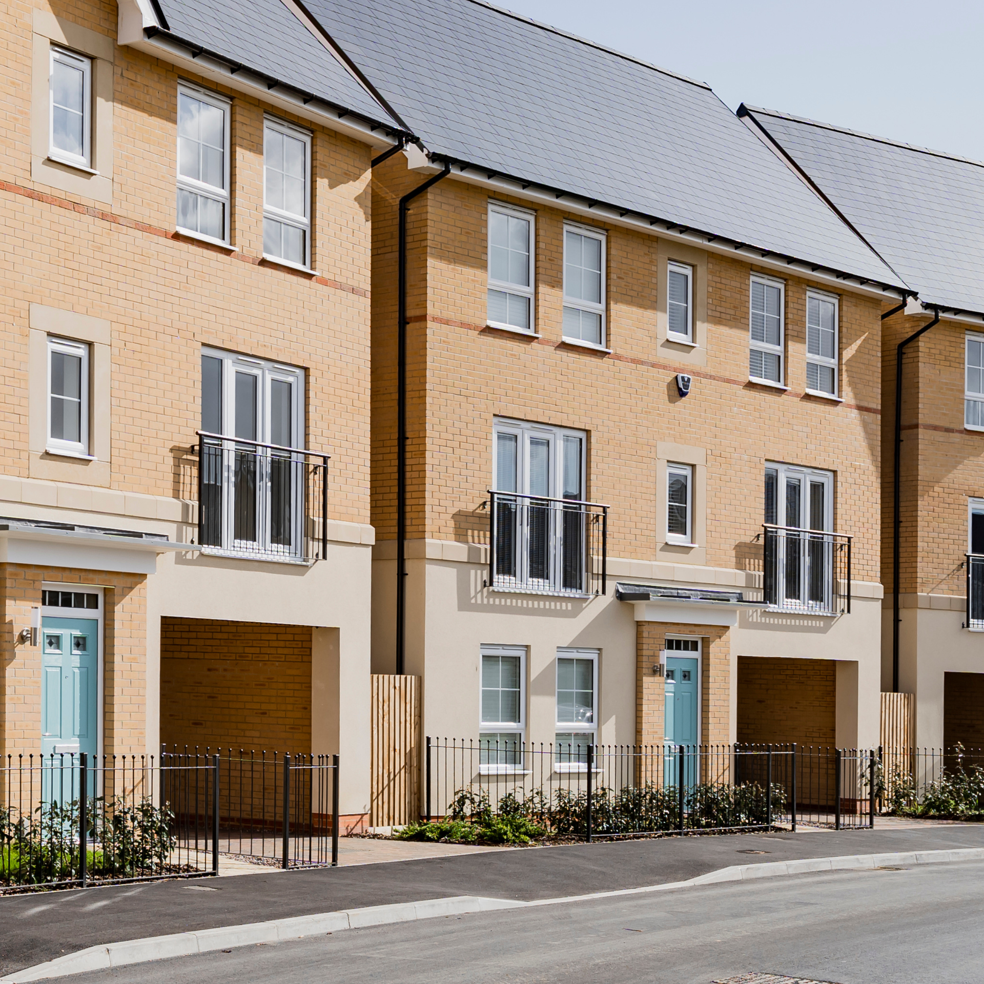 Row of new build townhouses with blue front doors