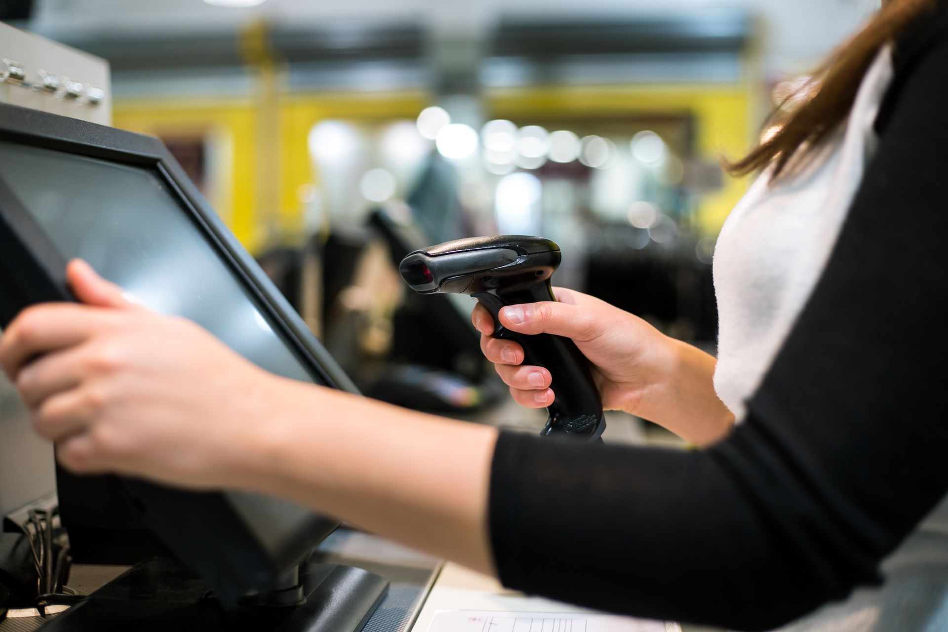 Person scanning a barcode on a checkout terminal in a store
