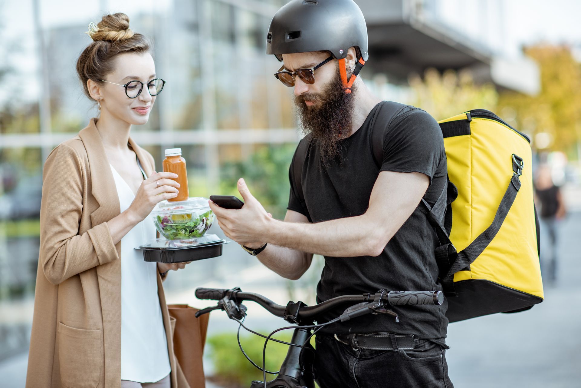 Person taps phone to card reader while another holds a smartphone with a green checkmark on screen.