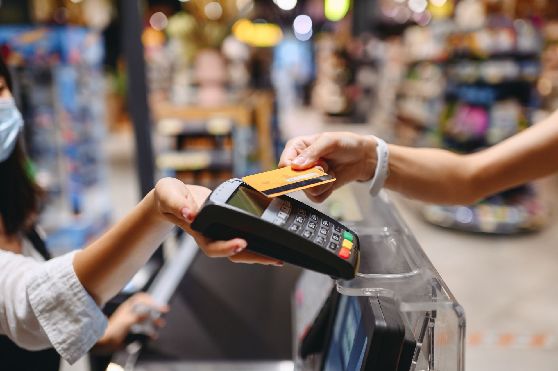 Contactless payment at a checkout counter with a card over a payment terminal
